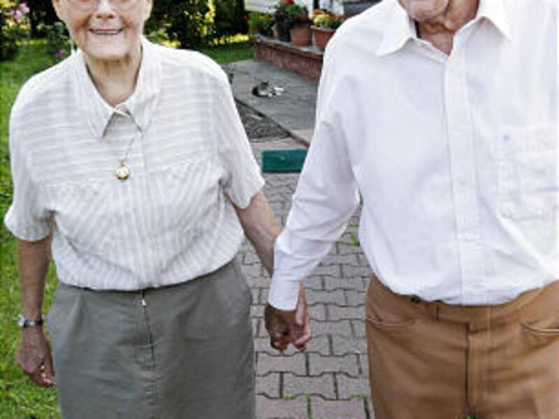 Elvira Profe and Fortunat Mackiewicz hold hands near their house in Poland.