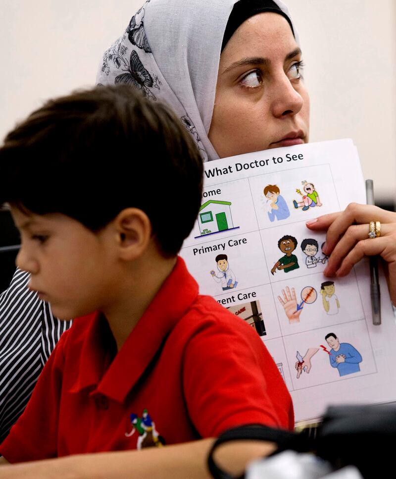 Eslam Hamad sits with his mother, Baraa Huraideen, as she learns how to navigate the health care system in America, at the Catholic Community Services office in Salt Lake City, June 5, 2017. Eslam is youngest of the three boys in the family.