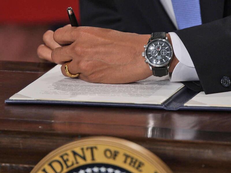 In this Jan. 21, 2009, file photo President Barack Obama signs one of five executive orders his first day on the job.
