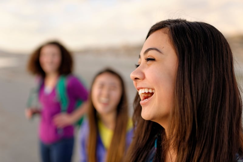 Three Young Women talk and laugh together during an activity.