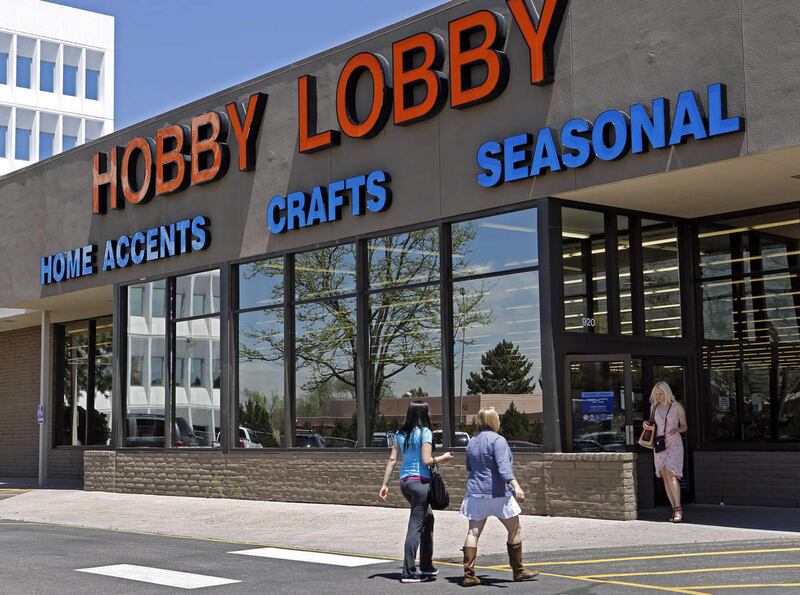 In this May 22, 2013, customers enter and exit a Hobby Lobby store in Denver. A federal judge says Hobby Lobby and a sister company will not be subject to daily fines for refusing certain birth-control for workers.