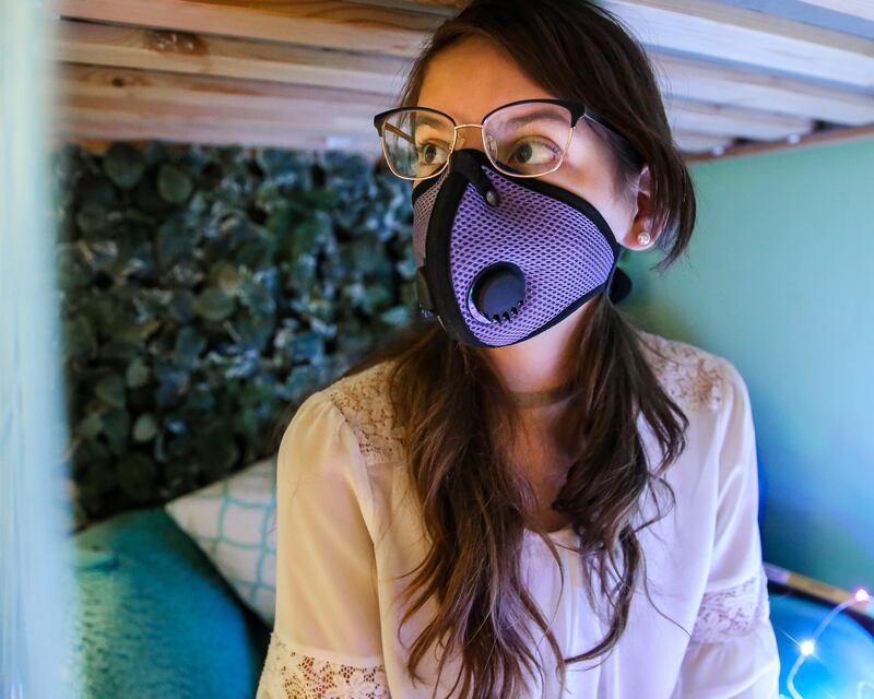 Sophie Weidmann, 13, sits on her bed with her air pollution mask on at her home in Salt Lake City on Thursday, Nov. 8, 2018.