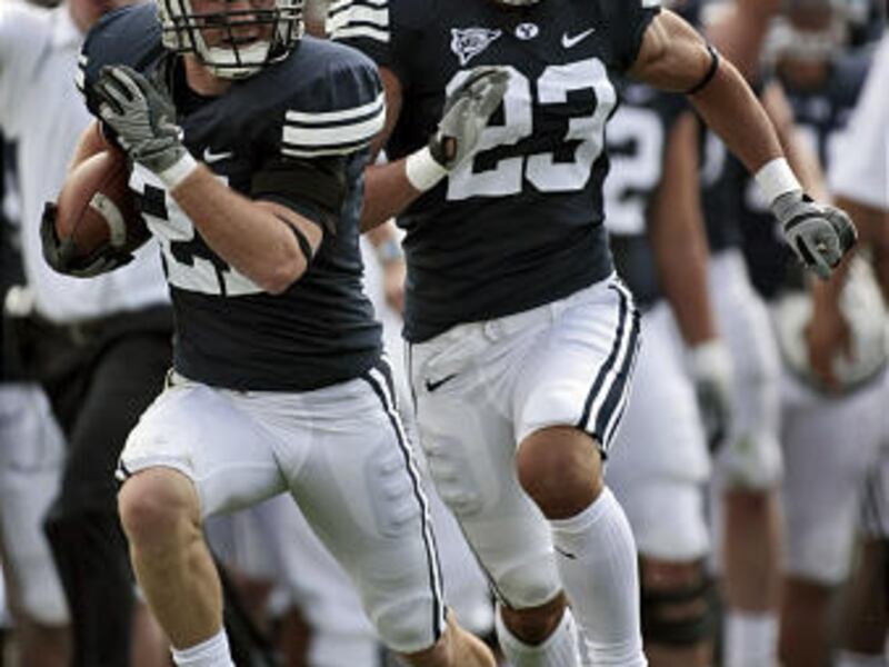BYU's Scott Johnson (21) is followed by his teammate David Tafuna (23) as he runs a fumble back for the opening touchdown as BYU faces Wyoming in Mountain West Conference action at Lavell Edwards Stadium in Provo Saturday, September 20, 2008. Photo by Ja