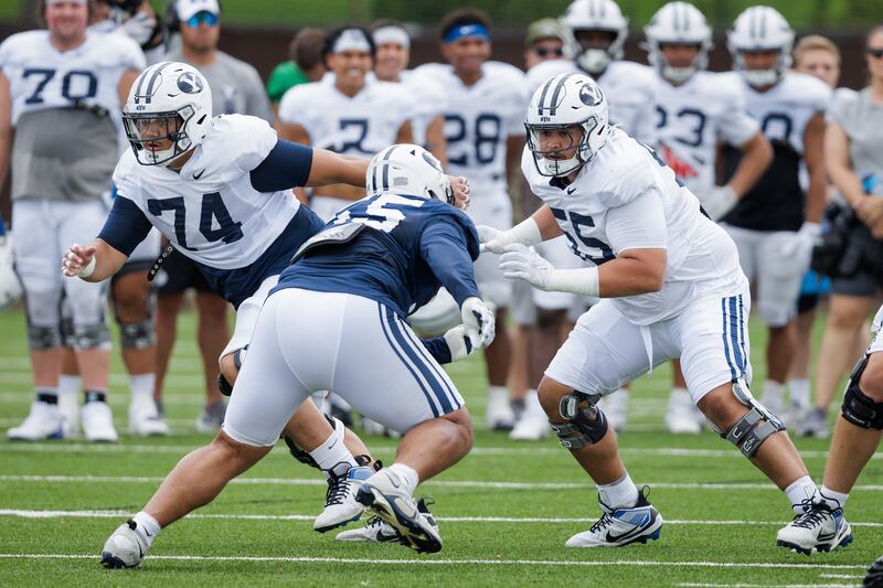 BYU offensive lineman Austin Leausa, left, gets in some work during practice Tuesday, Aug. 13, 2024.
