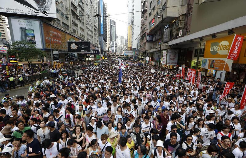 Protesters fill in a street during a march at an annual protest in downtown Hong Kong Tuesday, July 1, 2014.