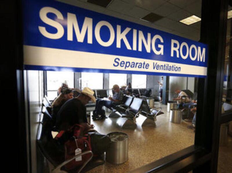 FILE: Travelers use a smoking room at Salt Lake City International Airport, Monday, Aug. 3, 2015.