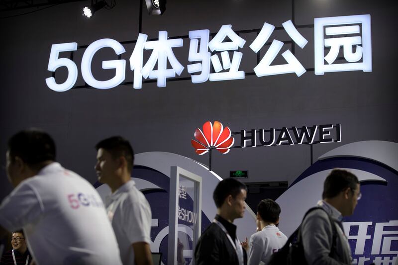 Visitors look at a display for 5G wireless technology from Huawei at the PT Expo in Beijing.