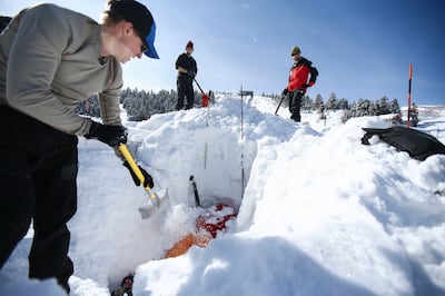 Colin Little, a wilderness medicine fellow at the University of Utah, is buried in snow by Scott McIntosh, an emergency doctor with University of Utah Health, to test the Black Diamond JetForce air bag by simulating an avalanche at the Utah Olympic Park i