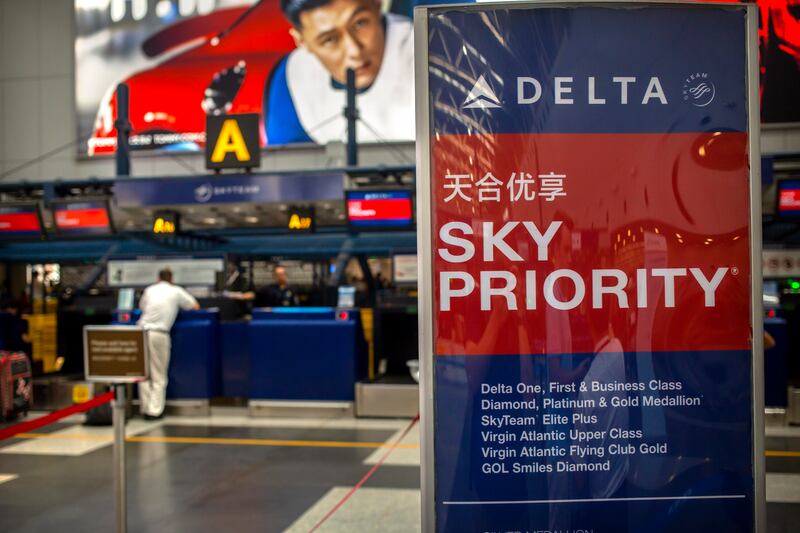In this July 6, 2018 photo, travelers check in for flights at the Delta Air Lines check-in counters at Beijing Capital International Airport. Chinese regulators said Thursday, June 4, 2020, that more foreign airlines will be allowed to fly to China as anti-coronavirus controls ease but it was unclear whether the change will defuse a fresh conflict with the Trump administration over air travel.