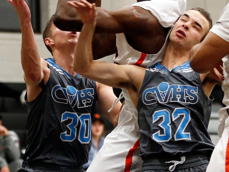 Brantzen Blackner, left, and Joey Lambeth of Canyon View High School defend Mady Sissoko of Wasatch Academy during basketball in Mt. Pleasant on Saturday, Jan. 6, 2018.