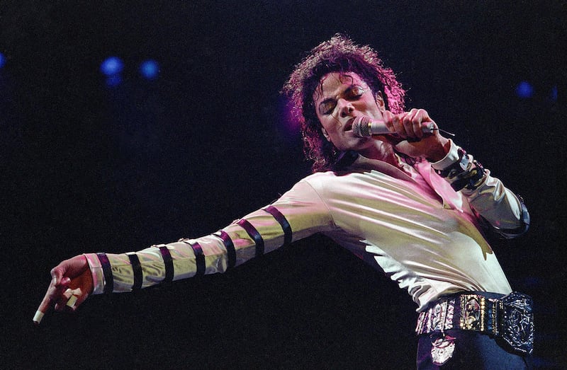FILE - In this Feb. 24, 1988 file photo, Michael Jackson leans, points and sings, dances and struts during the opening performance of his 13-city U.S. tour, in Kansas City, Mo.