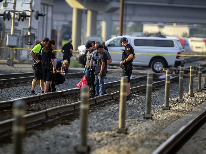 Officers investigate after a body was found on a railroad track between 800 South and 900 South at about 600 West in Salt Lake City on Saturday, Aug. 25, 2018. Police say an unidentified man died Saturday afternoon while trying to roll under a moving Unio