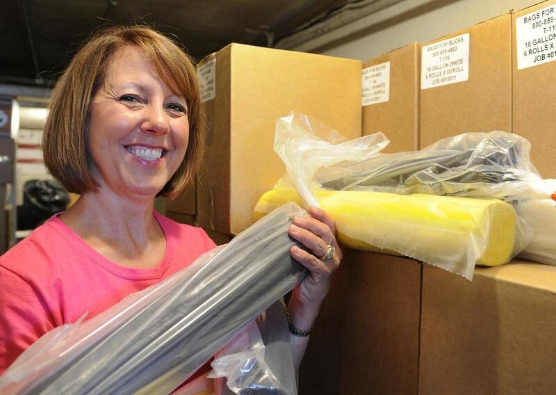 This July 15, 2013 photo shows Beth Hendrickson, principal of St. Ann Interparochial School, showing some of the trash bags being sold to raise money for the school in Morganfield, Ky. Many schools and PTAs sell candy and gift wrap to raise money for acti