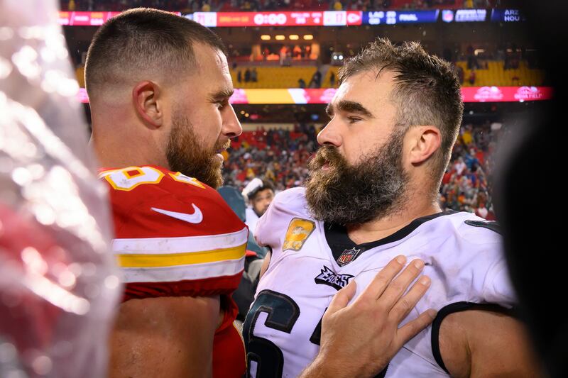Kansas City Chiefs tight end Travis Kelce, left, meets with his brother, Philadelphia Eagles center Jason Kelce, right, after a game on Nov. 20, 2023.