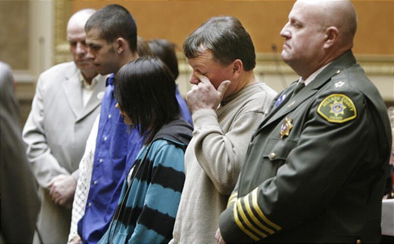 The family of slain officer Josie Fox, from left, father Russell Greathouse, son Spencer Greathouse, daughter Hunter Winn and husband Doug Fox, stand with Sheriff Robert Decker as they are honored by lawmakers Friday.