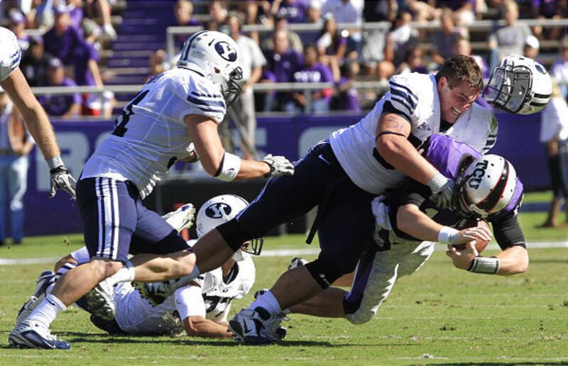 BYU's Jordan Richardson (94) loses his helmet as he tackles TCU quarterback Andy Dalton during his team's 31-3 loss to the Horned Frogs on Saturday afternoon. Dalton regrouped to throw four touchdowns.