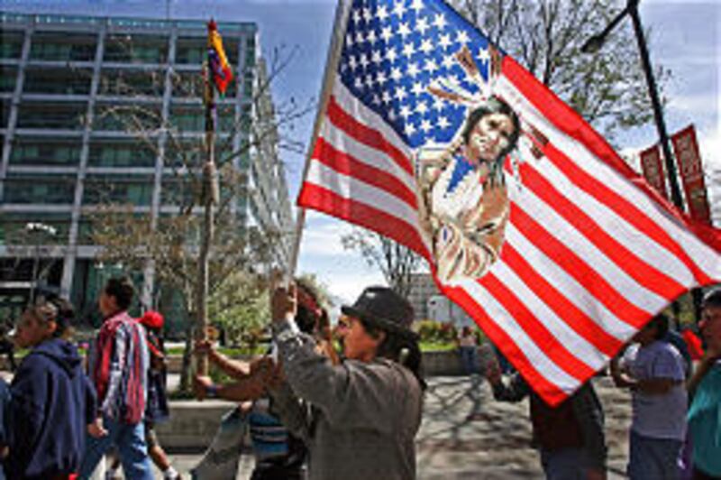 Darry Duran, center, of Salt Lake City, carries flag while marching downtown.