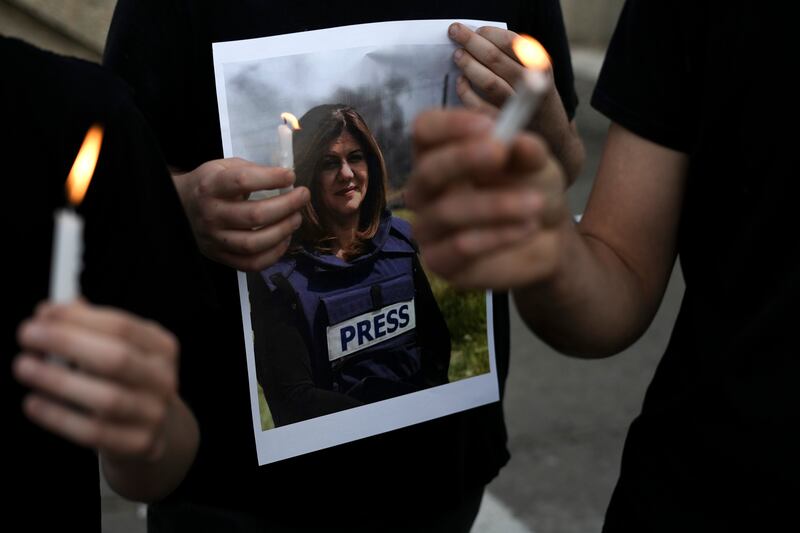 Protesters hold candles and a photo of slain Al Jazeera journalist Shireen Abu Akleh in Haifa, Israel, Wednesday, May 11, 2022. Abu Akleh was shot and killed on Wednesday while covering an Israeli military raid in the occupied West Bank. The broadcaster and two reporters who were with her blamed Israeli forces.