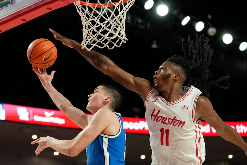 BYU guard Egor Demin, left, shoots against Houston forward Joseph Tugler during game in Houston, Saturday, Jan. 4, 2025.