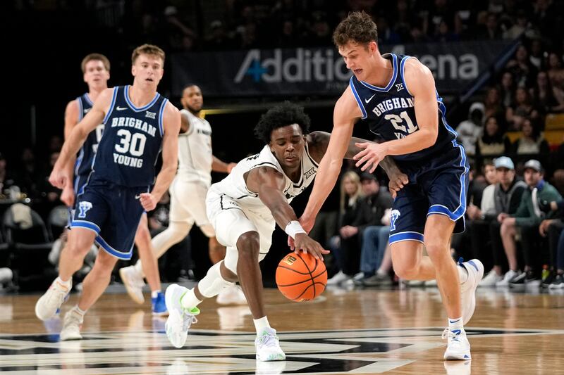 Central Florida’s Jaylin Sellers, center, and BYU’s Trevin Knell (21) battle for the ball during game, Jan. 13, 2024.