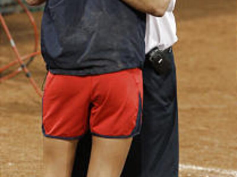 USA softball coach Mike Candrea hugs pitcher Cat Osterman after the team lost to Japan 3-1 in the gold-medal game.