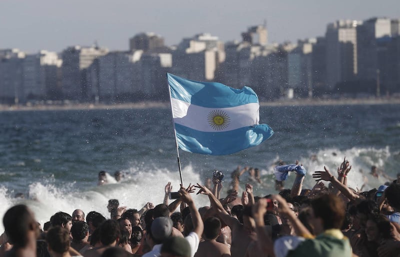 Fans of the Argentina national soccer team wave their country's national flag as they celebrate their team's World Cup quarterfinal 1-0 victory over Belgium, on Copacabana beach, in Rio de Janeiro, Brazil, Saturday, July 5, 2014.