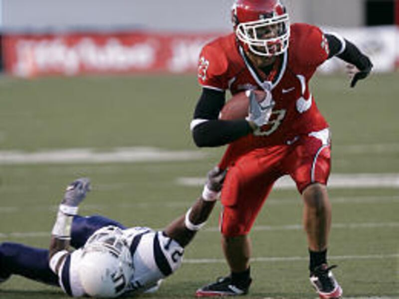 USU's Jarrett Bush tries to tackle Utah's John Madsen as he runs for a touchdown in Utah's win over Utah State on Saturday.