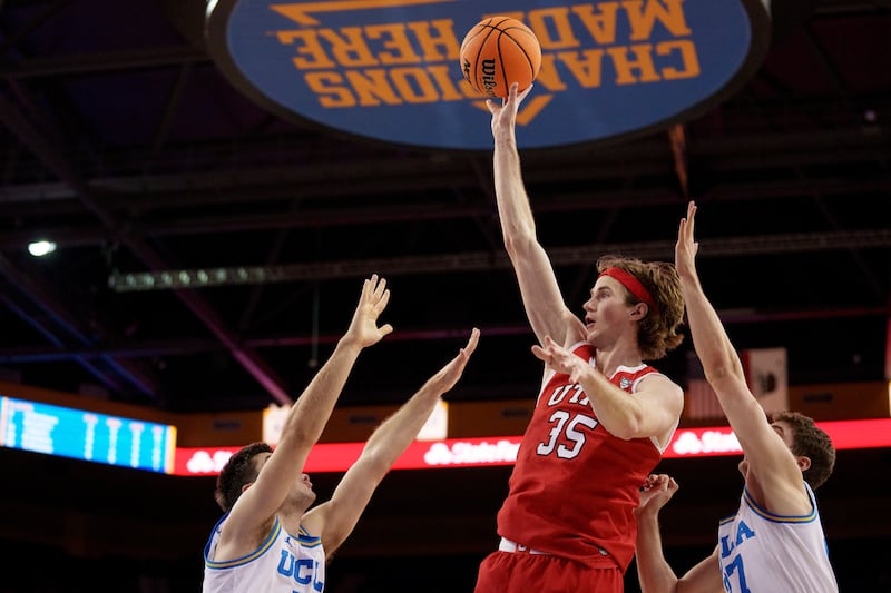 Utah center Branden Carlson (35) shoots against UCLA guards Lazar Stefanovic, left, and Jan Vide, right.