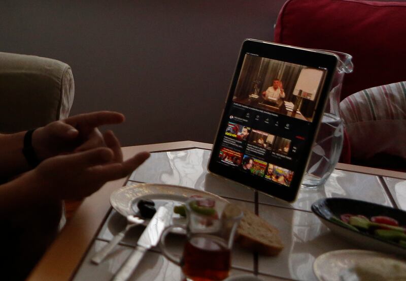 A man talks to his wife over breakfast in Istanbul, while watching on a tablet Sedat Peker, a Turkish fugitive crime boss on a video.