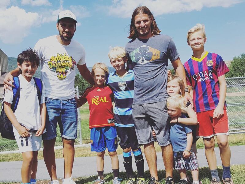 Adam Brown and some of his children pose for a picture with Javier Morales and his son after a soccer game.
