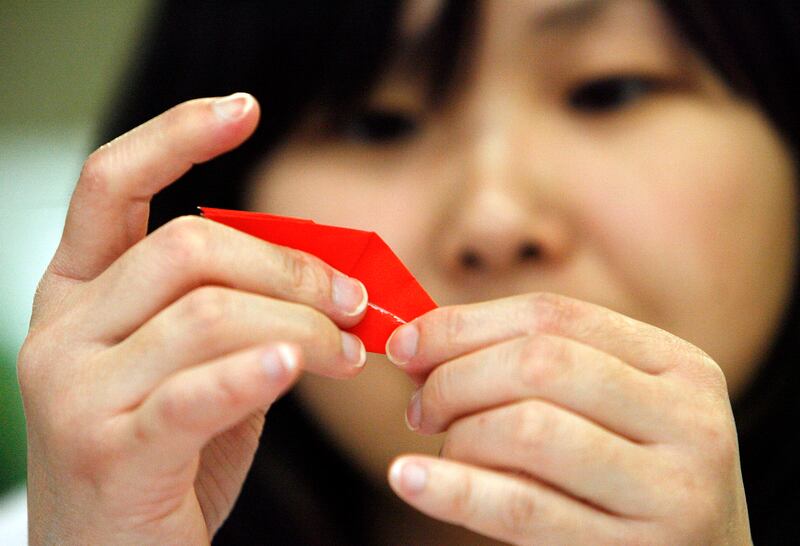 Yuka Asaumi of the UVU Japan Club does origami as part of a fundraiser for Japan at Utah Valley University in Orem in 2011.
