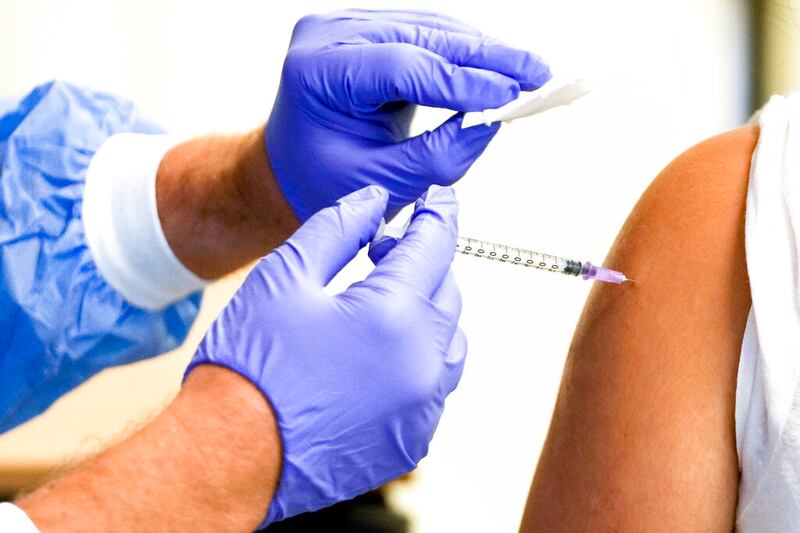 A doctor vaccinates a student with the Moderna COVID-19 vaccine.