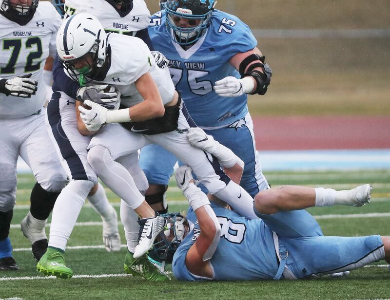 Sky View’s Kimball Jackson (8) tackles Ridgeline QB Jackson Olsen in the 4A football state semifinal game in Smithfield on Friday, Nov. 13, 2020.