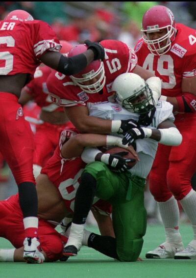 Ute defensive lineman Henry Kaufusi (57) wraps up a Hawaii ball carrier.