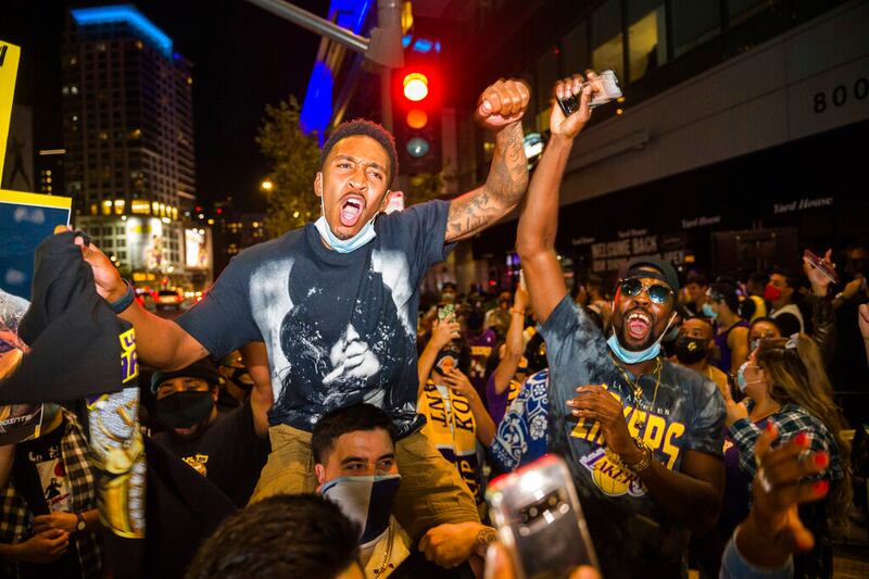In this Oct. 11, 2020, file photo, fans in Los Angeles celebrate after the Los Angeles Lakers defeated the Miami Heat in Game 6 of basketball’s NBA Finals to win the championship.