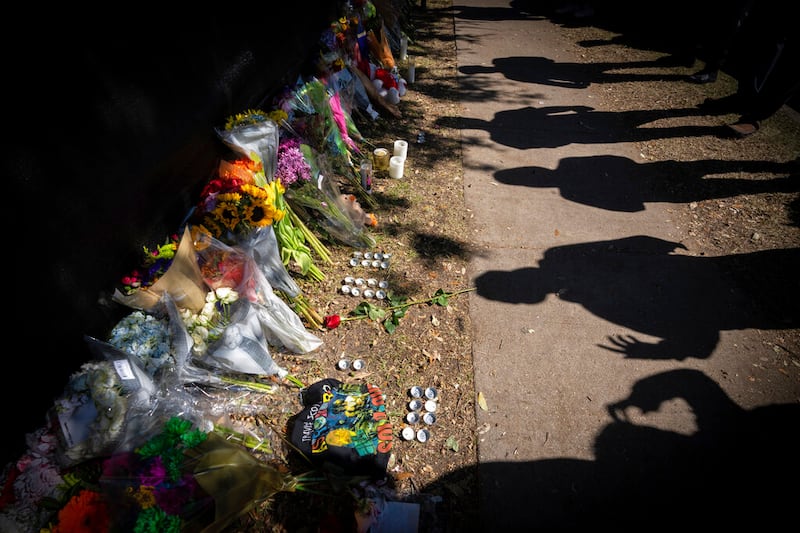 Visitors cast shadows at a memorial to the victims of the Astroworld concert.