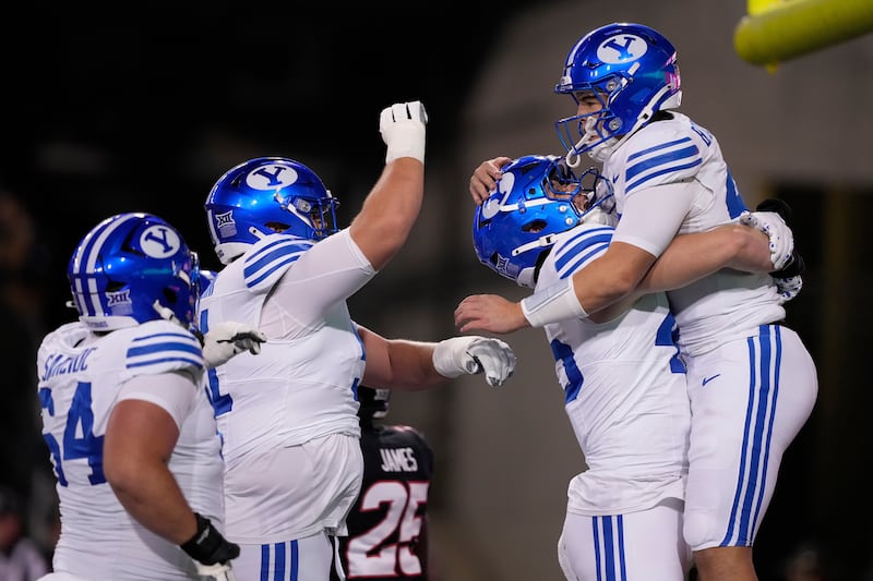BYU quarterback Bear Bachmeier (47), right, celebrates with teammates after scoring a touchdown during game against Cincinnati, Saturday, Nov. 22, 2025, in Cincinnati.