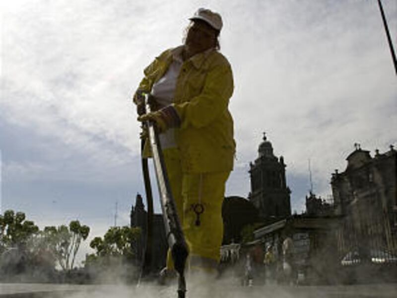 A worker using a sidewalk steam-cleaner removes chewing gum in Mexico City.