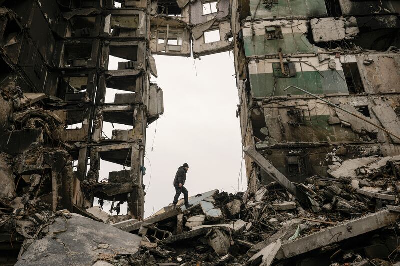 A resident looks for belongings in a building destroyed during fighting between Ukrainian and Russian forces.