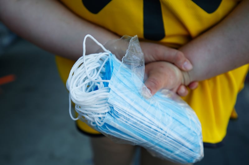 A Walmart employee holds a bag of face masks.