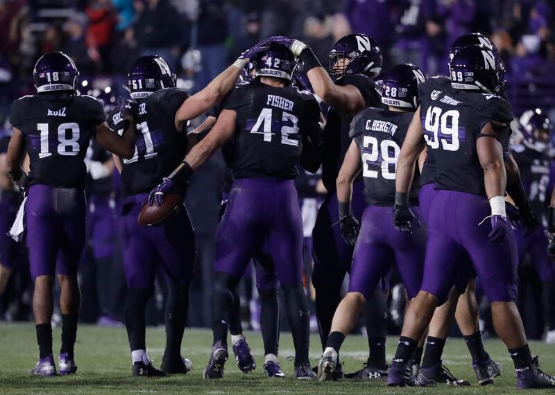 Northwestern linebacker Paddy Fisher (42) celebrates with teammates after intercepting during the second half of an NCAA college football game against Illinois in Evanston, Ill., Saturday, Nov. 24, 2018. Northwestern won 24-16. (AP Photo/Nam Y. Huh)