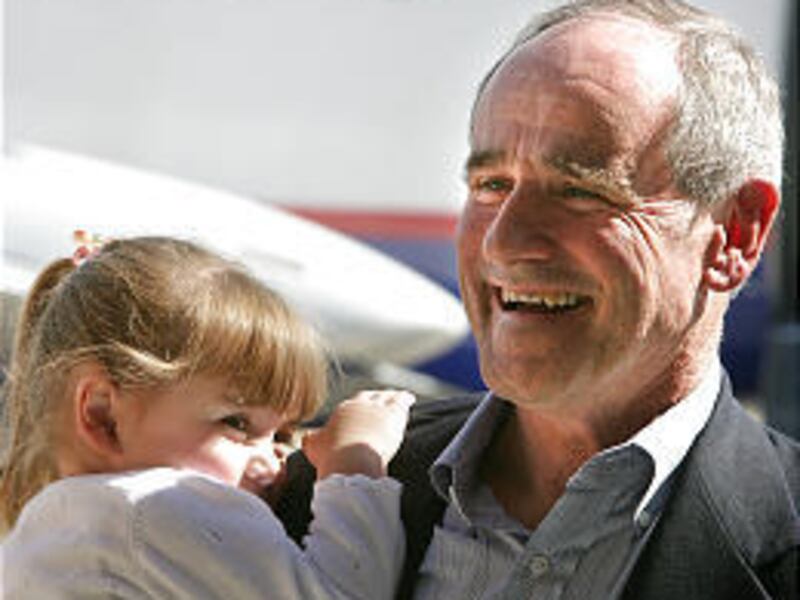 Newly appointed Idaho Gov. Jim Risch holds his granddaughter Jessie Risch, 3, and talks with the media after flying into Boise.