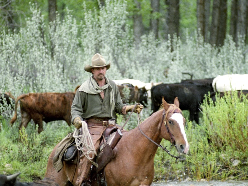 Kevin Costner sits on a horse during a movie production.