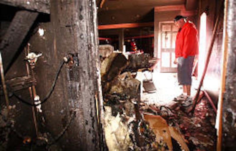 Casey Kalm, who owns Pinky's, looks over fire damage. He estimated that $5,000 in cash had been stolen.