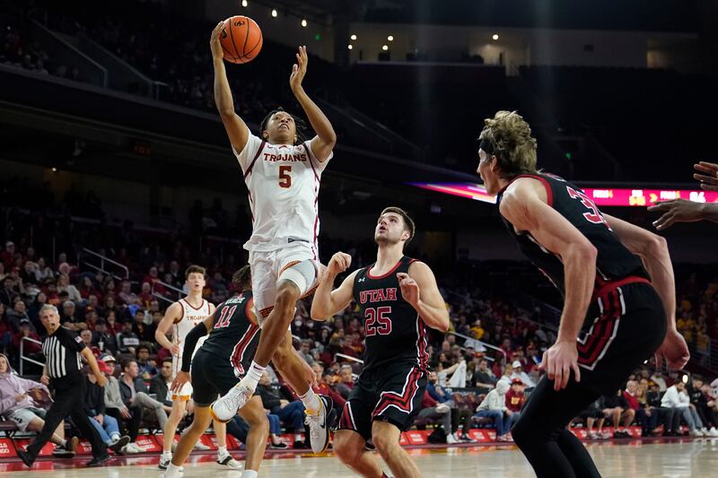 Southern California guard Boogie Ellis (5) drives past Utah guard Rollie Worster (25) during the second half of an NCAA college basketball game Saturday, Jan. 14, 2023, in Los Angeles. (AP Photo/Marcio Jose Sanchez)
