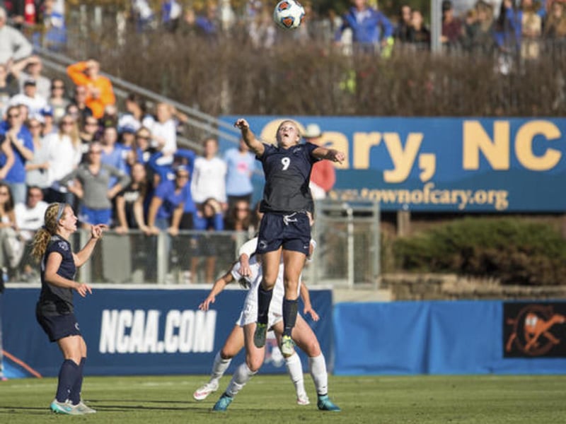 FILE - In this Dec. 6, 2015, file photo, Penn State"™s Frannie Crouse (9) jumps for a header as teammate Emily Ogle, left, watches during the NCAA Women's College Cup soccer final against Duke in Cary, N.C. The NCAA relocated its men's basketball regional