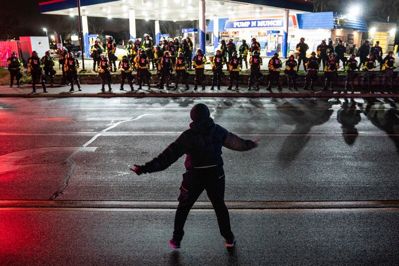 A demonstrator heckles authorities who advanced into a gas station after issuing orders for crowds to disperse during a protest against the police shooting of Daunte Wright, late Monday, April 12, 2021, in Brooklyn Center, Minn.