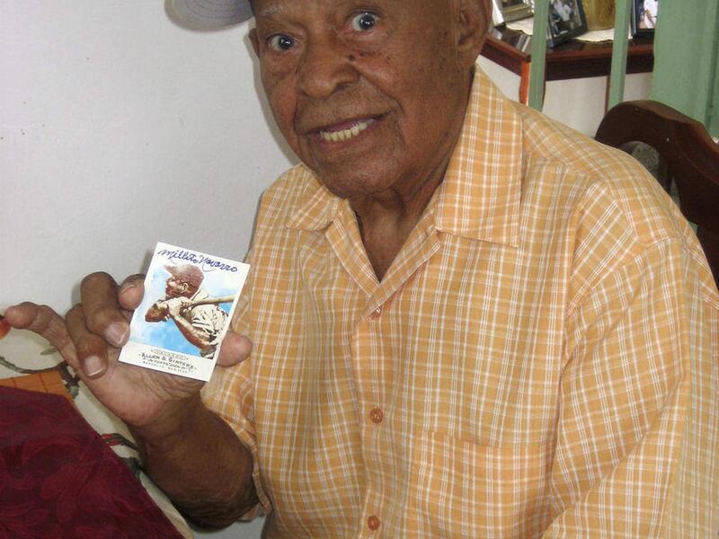 ** ADDS DATE OF NAVARRO'S DECEASE ** FILE - In this July 29, 2010 file photo, former professional baseball player Emilio "Millito" Navarro, 104, holds his signed baseball card while posing for a picture in his home in Ponce, Puerto Rico. Navarro, who wa