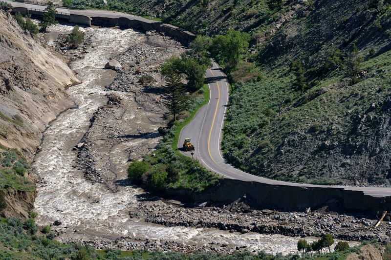 A bulldozer sits surrounded by sections washed away by recent floodwaters at Yellowstone National Park.