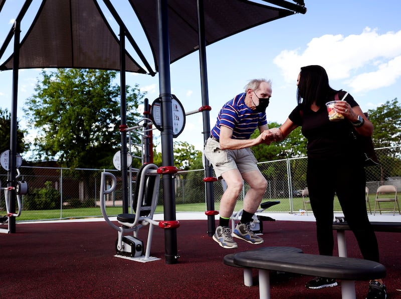 Barry White does plyometric exercises with help from Julia Garcia at an AARP FitLot at Bickley Park in South Salt Lake.